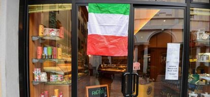 Una bandera italiana a la entrada de una panadería en la ciudad de Albino (Lombardía).
