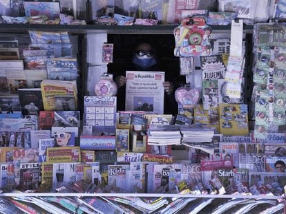 Un quiosquero sostiene una copia de 'La Reppublica' en un puesto en Livorno, Italia.