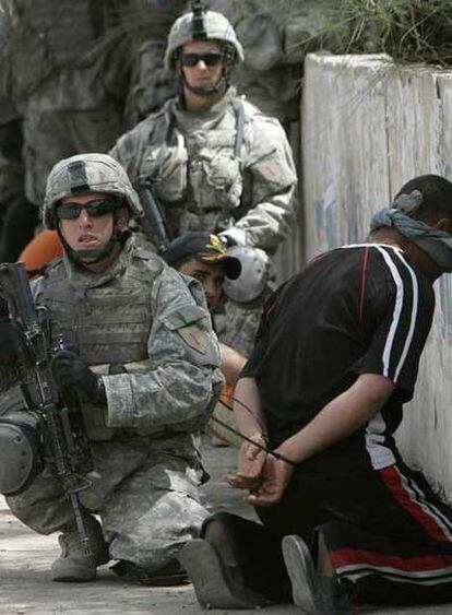 Soldados de Estados Unidos, junto a un supuesto miembro de la insurgencia iraquí arrestado ayer en Bagdad.