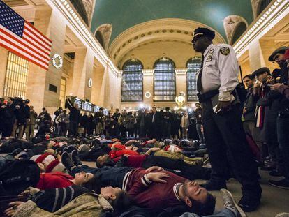 Decenas de activistas se han tumbado en el vestíbulo de la Estación Central de Nueva York para protestar por la resolución judicial que deja libre al policía que estranguló a Eric Garner, un hombre negro de 43 años.