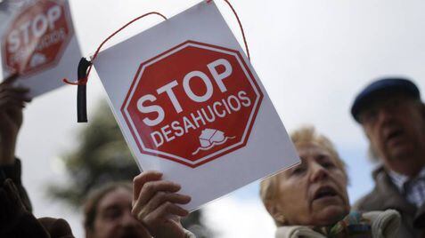 Miembros de Kaleratzeak Stop Desahucios e IRPH-STOP de Gipuzkoa participan en una concentración frente a la sede de Kutxabank en San Sebastián. En vídeo, declaraciones de Javier Montero, abogado de la asociación Adicae.