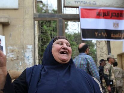 Una egipcie sostiene una foto de Abdelfatá al Sisi en la entrada de un colegio electoral en El Cairo, este miércoles.