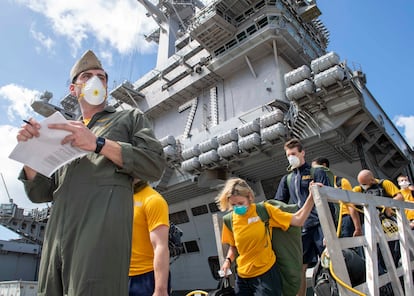 This handout photo released by the US Navy shows sailors assigned to the aircraft carrier USS Theodore Roosevelt (CVN 71) wearing face masks as they depart the ship to move to off-ship berthing, April 10, 2020. - A sailor who was aboard the USS Theodore Roosevelt aircraft carrier died on April 13, 2020 of COVID-19, the first fatality from nearly 600 confirmed cases among its crew, the US Navy said. (Photo by Chris LIAGHAT / US NAVY / AFP) / RESTRICTED TO EDITORIAL USE - MANDATORY CREDIT "AFP PHOTO / US NAVY / MC1 CHRIS LIAGHAT " - NO MARKETING - NO ADVERTISING CAMPAIGNS - DISTRIBUTED AS A SERVICE TO CLIENTS