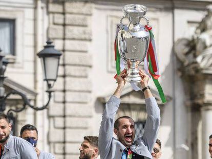 Los jugadores de la selección italiana levantan el trofeo a su llegada a Roma.