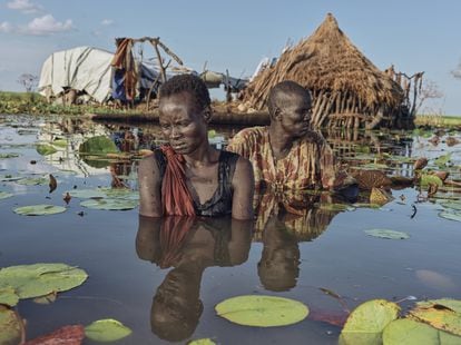 Retrato de Changjaik Wal y su esposa Nyatoya Mawich fuera de su casa flotante. Los hombres van a pescar en lugares lejanos, así que si todas las mujeres tienen que meterse en el agua caminando para buscar canoas. Sudán del Sur, 2022.