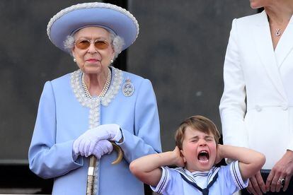 El príncipe Luis, hijo de Guillermo de Inglaterra y Kate Middleton, junto a su abuela, la reina. El niño, de cuatro años, se tapa los oídos durante el vuelo de los cazas de la Royal Air Force sobre Buckingham.