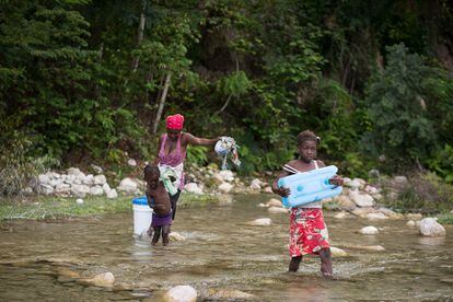 Las mujeres acarrean agua en un río cercano mientras que los hombres transportan madera de los escasos árboles que aún quedan en pie.
