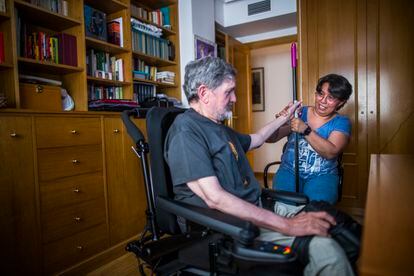 Delmi ayuda a Carlos a hacer ejercicios de rehabilitación en su casa.