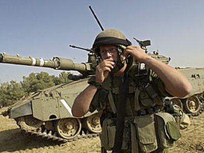Un soldado israelí, junto a un carro de combate en la franja de Gaza.