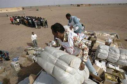 Miembros de la Media Luna Roja descargan provisiones para los inmigrantes en Bir Lehlu.