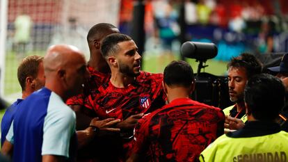 Mario Hermoso es sujetado por miembros del cuerpo técnico del Atlético tras su enfrentamiento con los ultras rojiblancos en el Metropolitano al término del partido con el Villarreal disputado el pasado domingo.