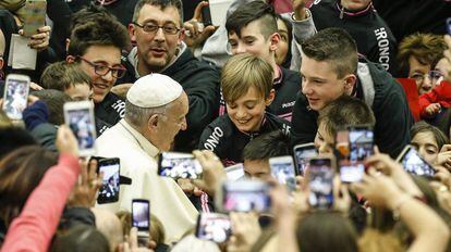 El papa Francisco saluda a unos j&oacute;venes a su llegada al aula Pablo VI en el Vaticano.