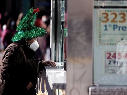 Una mujer compra lotería en la Puerta del Sol a un día de las campanadas, a 30 de diciembre de 2021, en Madrid, (España).