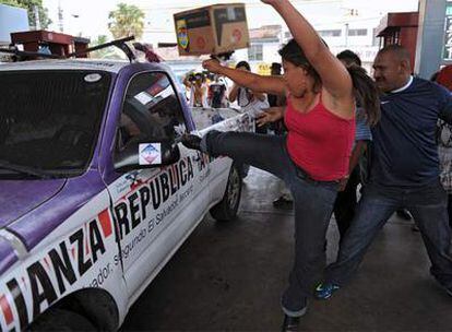 Vendedores callejeros atacan un coche en San Salvador.