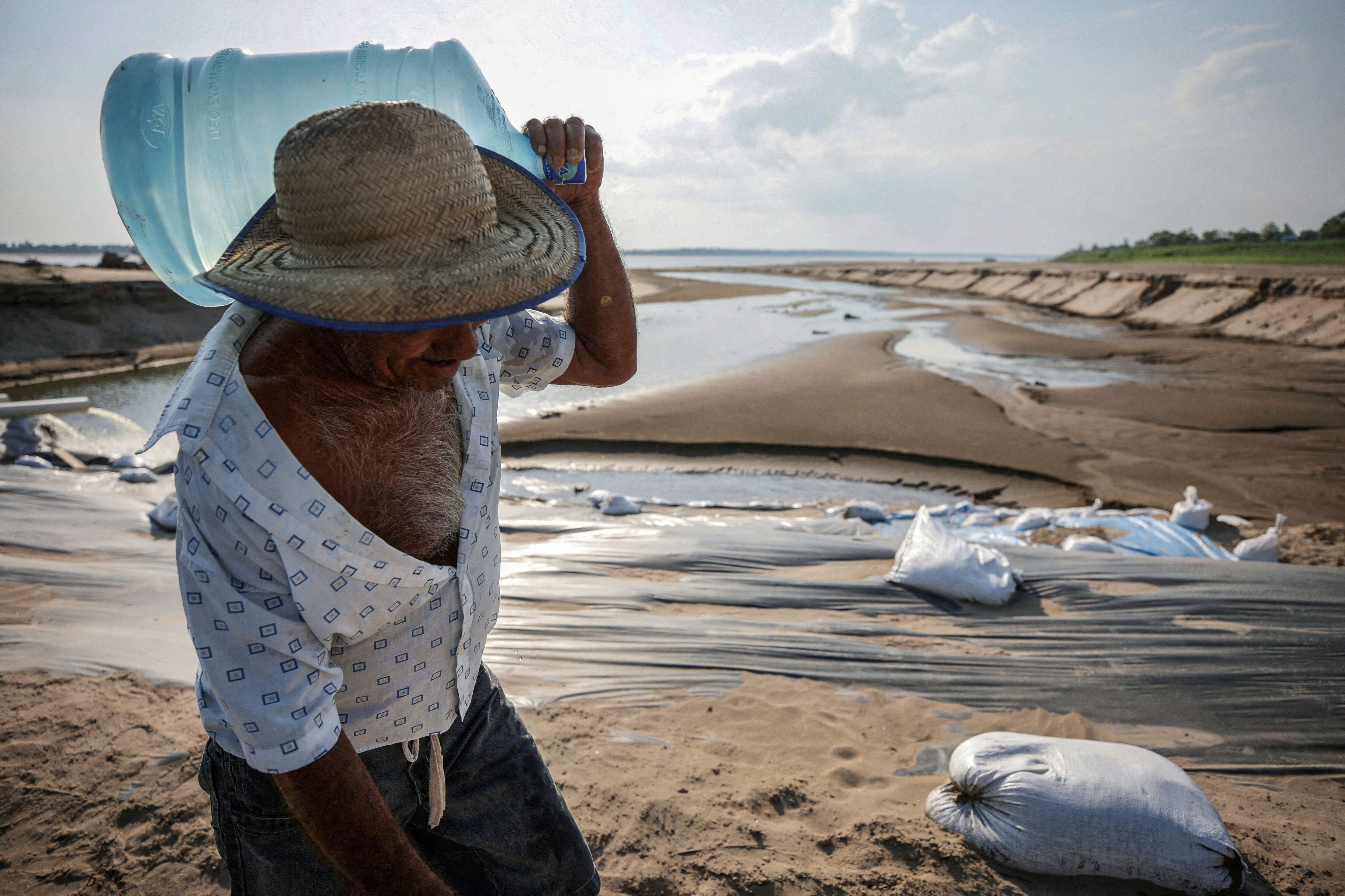 Un hombre carga un contenedor con agua por el lecho de un río en la Amazonia, el 26 de octubre.