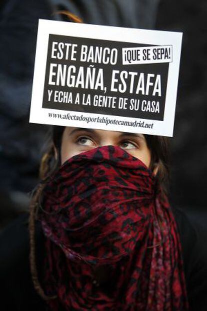 Una manifestante protesta frente a la sede de Bankia en Madrid, tras las crisis de la entidad, el 14 de abril