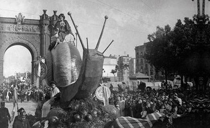 Carrossa engalanada amb un cargol gegant a la Cavalcada dels Mercats de 1910 passant per l’Arc de Triomf.