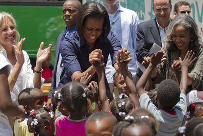 La primera dama de EE UU, Michelle Obama, (en el centro), junto a la primera dama de Haití, Elisabeth Debrosse, (a la derecha) y la esposa del vicepresidente estadounidense Joseph Biden, Jill Biden, en su visita a Haití.