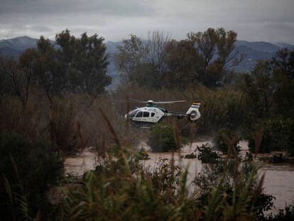 Un helicóptero de la Guardi Civil sobrevuela un campo inundado cerca del barrio de Doñana en Cartama, Málaga, el 4 de diciembre de 2016.