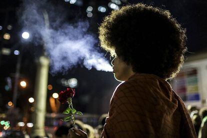 Una mujer sostiene una flor en una manifestación política en Rio de Janeiro