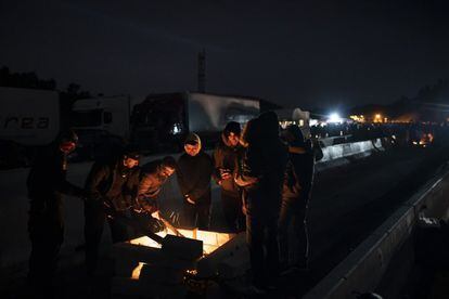 Manifestantes independentistas se calientan en una hoguera durante el bloqueo de carretera en un importante paso fronterizo entre Francia y España cerca de La Jonquera en Girona.