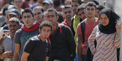 Un grupo de refugiados esperan para cruzar la frontera entre Macedonia y Grecia, cerca de Gevgelija (Macedonia).