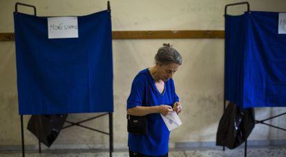 Una mujer sostiene su papeleta antes de votar, en Atenas.