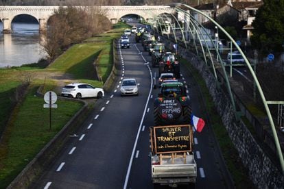 Los agricultores franceses marchan con sus tractores por la carretera. Uno de ellos (abajo) porta un cartel que dice "Ahorro y transmisión, código de honor del agricultor".