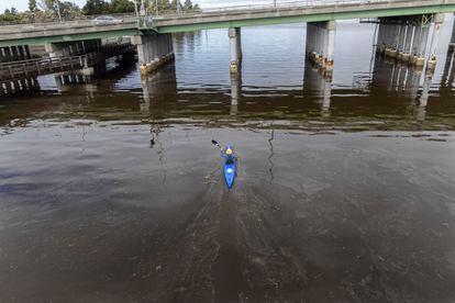Un hombre rema a bordo de un kayak sobre las aguas contaminadas por algas cerca del puente Bay Farm, en la ciudad californiana de Alameda, el 25 de agosto de 2022. 