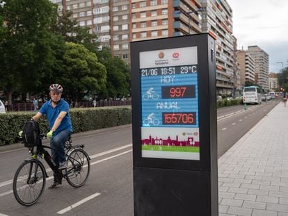 Un ciclista junto al cartel luminoso de la avenida de Isabel la Católica que indica el número de usuarios diario y anual del carril bici.