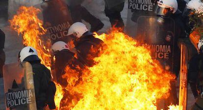 Policías griegos atacados con cócteles molotov durante las protestas del domingo en Atenas.