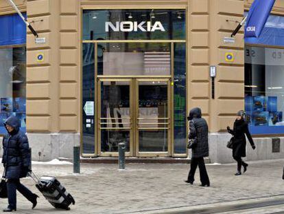 Varios viandantes pasan delante de una tienda que la fabricante de tel&eacute;fonos m&oacute;viles Nokia tiene en Helsinki.