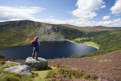 Un senderista contempla el lago Tay, en el parque nacional de las montañas de Wicklow, en Irlanda.