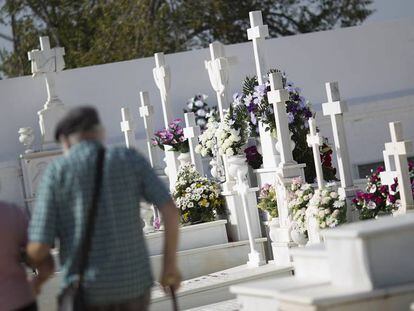 Una pareja de ancianos visita el cementerio de Sanl&uacute;car la Mayor (Sevilla).