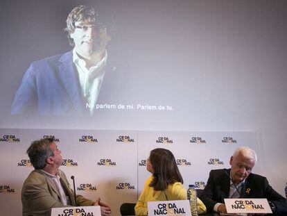 Els diputats Antoni Morra i Gemma Geis i el delegat Ferran Mascarell, i a la pantalla, l'expresident Puigdemont.