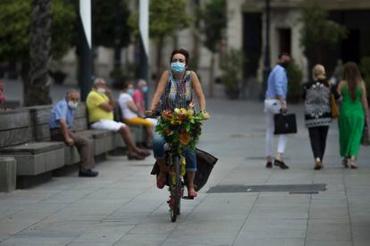 Una mujer con mascarilla pasea en bicicleta por el centro de Sevilla a principios de septiembre.