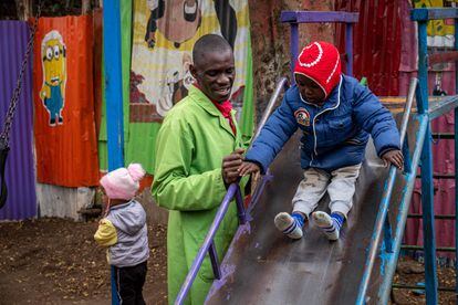Otieno juega con un niño en un parque infantil construido en una parcela que antes servía de vertedero.