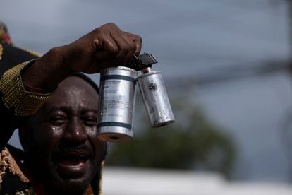 Un manifestante sostiene las latas de gas lacrimógeno utilizadas por la policía haitiana para repeler las protestas en contra del primer ministro y de la iniciativa de intervención extranjera.