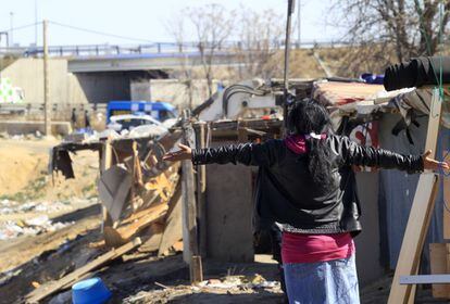 Agentes de policía - un grupo de antidisturbios en 16 furgones policiales, caballería y un helicóptero que han acompañado a las excavadoras- han pasado toda la mañana allí para desalojar y derribar seis viviendas. En la foto, una mujer presencia la operación en el poblado.