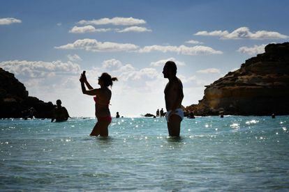 Una mujer se toma un selfie junto a otro hombre mientras se bañan en Isla Conejo. 