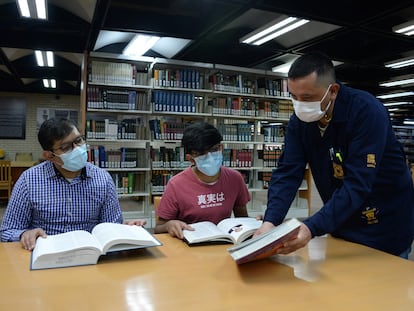 Un bibliotecario asiste a dos visitantes de la Biblioteca Nacional, en Ciudad de México, en mayo.