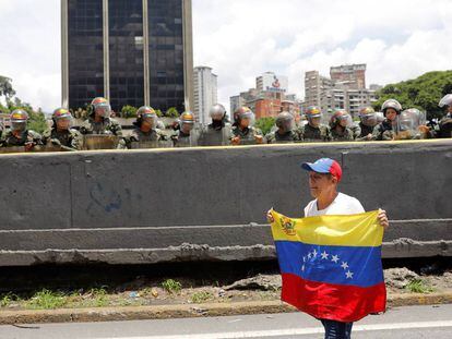 Una mujer sujeta una bandera venezolana durante una manifestación contra el Gobierno de Maduro.