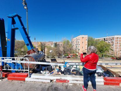 Pilar Pardo toma fotos del depósito de basura que el Ayuntamiento de Madrid ha colocado frente a su vivienda, en uno de los bloques de pisos que aparecen al fondo.