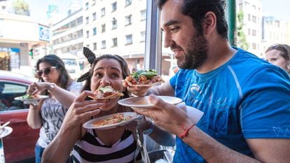 Una pareja comiendo una tostada de ceviche en el Caguamo (marisquería de calle).