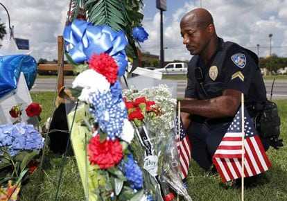 Un polic&iacute;a de Baton Rouge rinde homenaje a los agentes asesinados en el lugar del atentado, el lunes.   