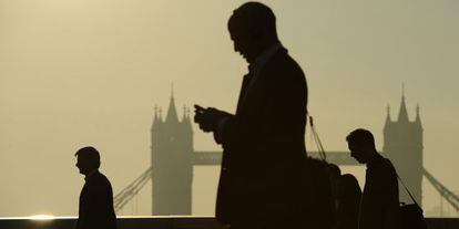 Unos directivos manejan sus móviles en Londres.