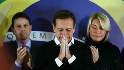 El exgobernador João Doria, tras anunciar su renuncia este lunes flanqueado por el presidente de su partido y por su esposa.