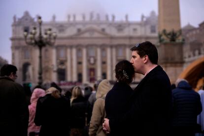 Una pareja asiste al funeral del papa emérito en el Vaticano.  