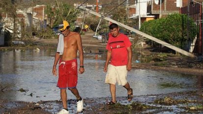 Dos hombres caminan por una calle tras el paso del hurac&aacute;n Patricia en el municipio de Francisco Villa, en el estado mexicano de Jalisco.