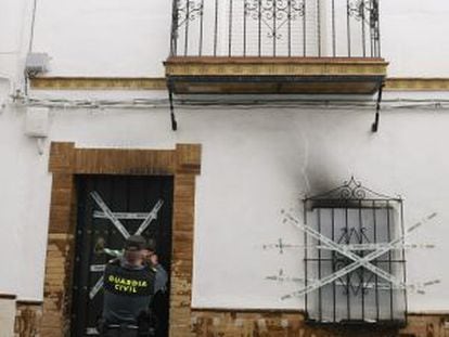 Un agente precinta la vivienda donde se produjo el incendio el jueves.